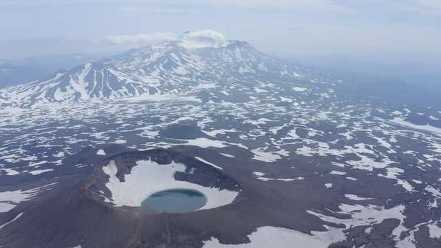 Gorely Volcano crater lake with Mutnovsky Volcano on the background. Kamchatka, Russia