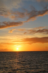 Beautiful yellow sunset over the ocean and different color sky