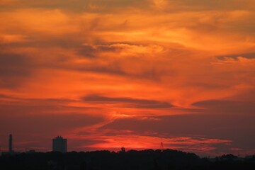 Fototapeta premium Beautiful fiery orange sunset over the city, natural background