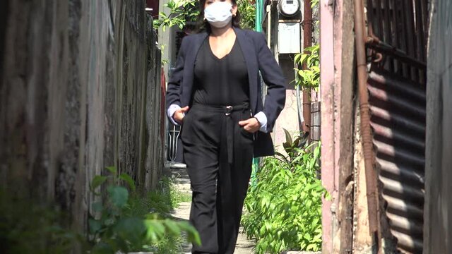 Woman Wearing Mask Walking In Small Pathway