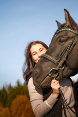 Obraz premium Woman riding a horse in filed in autumn day and blue sky background