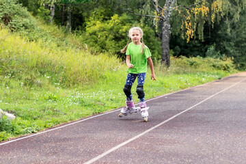 An active girl learns to roller skate on a hard surface at the stadium.