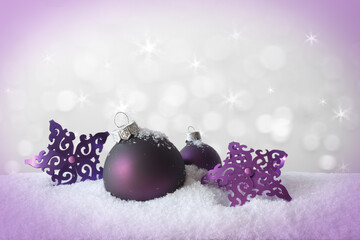 Purple christmas ball and stars on snow, sparkling white background, vignette effect, copy or text space.