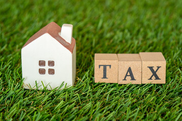 家の税金のコンセプト（ミニチュアの家とTAXの文字）