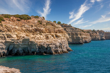 Beautiful coast line and sunny beaches in the portuguese region of Algarve. Natural caves at Carvoeiro beach, Algarve Portugal. Rock cliffs and turquoise sea water