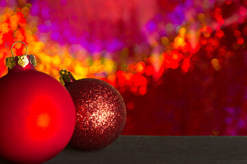 Christmas balls in front of a background sparkling in gold and red, copy or text space.