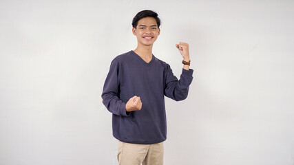 young man clenching both hands up and down while smiling isolated on white background
