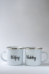 Two white enamel mugs with writings 