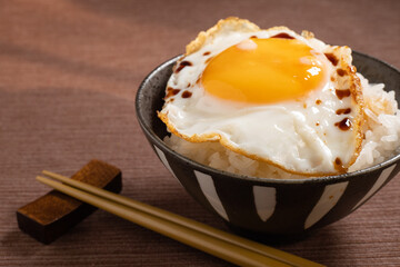 ご飯の上に乗せられた醤油の掛かった目玉焼き