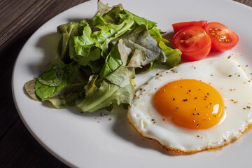 白い皿に盛りつけられた目玉焼きとサラダ