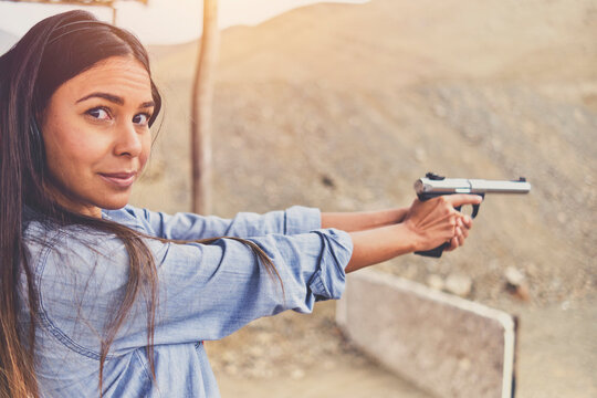 Woman releasing stress, Instructor helping woman with gun