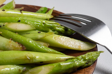 木のボウルに盛り付けられたアスパラガスの炒め物