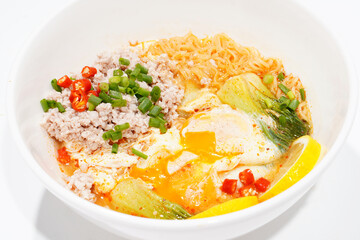 Asian food, minced pork and egg noodles in a cup on white background.