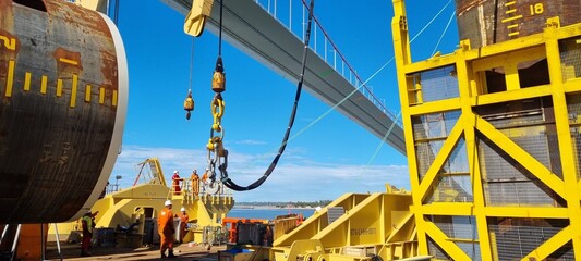 a crane lifts a pile during offshore construction operation