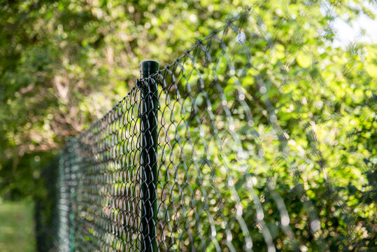Close up of green garden fencing. Green Plastic Coated Wire Fencing. PVC coated wire mesh.