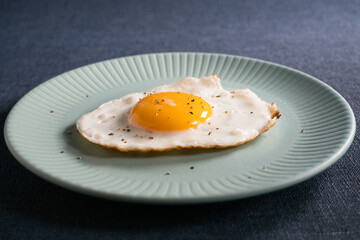青い皿に盛りつけられた目玉焼き