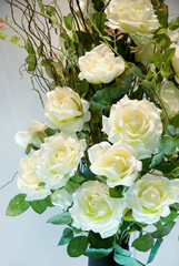 White plastic roses bouquet with green leafs