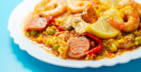 Delicious paella, cooked risotto rice with chicken thigh, king prawns, tomatoes and  chorizo