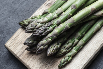 Bunch green asparagus on wooden board