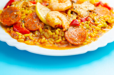 Delicious paella, cooked risotto rice with chicken thigh, king prawns, tomatoes and  chorizo