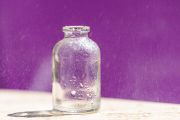 Obraz na płótnie Canvas bouteille transparente en vert glacée sur fond violet