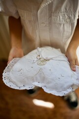 a boy is carrying a heart shaped white cushion on which wedding rings are laying