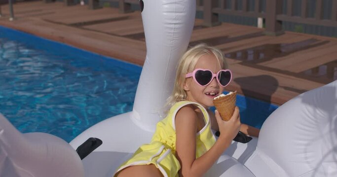 child swims on swan in blue pool