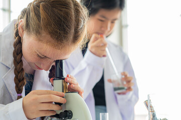 group children study science subjects and do experiments and look microscope