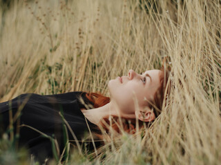 Woman in a black dress lies on the grass nature freedom rest