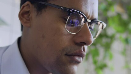 Black man freelancer working on laptop, reflection in eyeglasses, close-up face - Powered by Adobe
