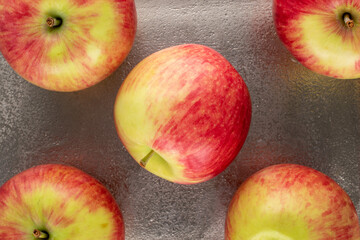 Several ripe apples on a metal tray, top view.