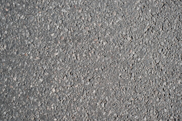 Textured background of gray asphalt, top view. Large granules and stones, road structure, backdrop...