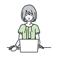 デスクで座ってPCを使っているオフィスカジュアルの女性