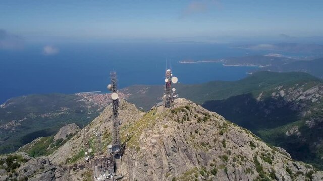 Aerial Drone video of the summit of Monte Capanne with radio antenna on a sunny partly cloudy summer day on Isola d'Elba, Italy