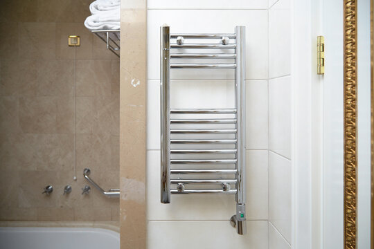 towel dryer, bathroom heater with chrome coating on the wall in the bathroom