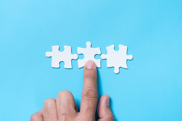 Hand push a piece of jigsaw puzzle to complete the mission for business merging concept or...