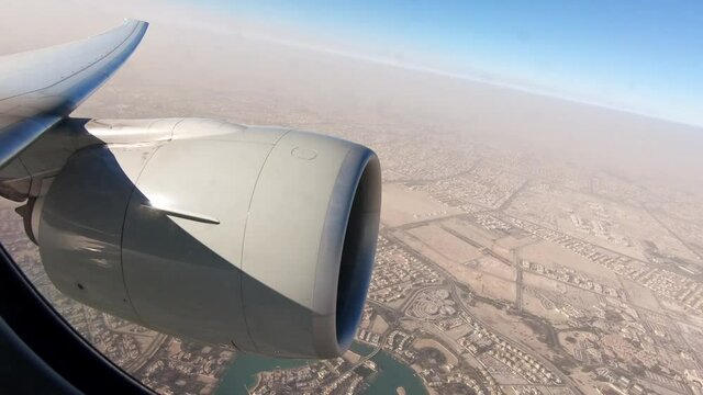 Airplane wing view flying over Doha in Qatar 