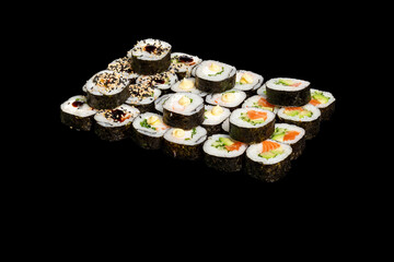 Japanese food: maki and nigiri sushi set on black background. side view composition.