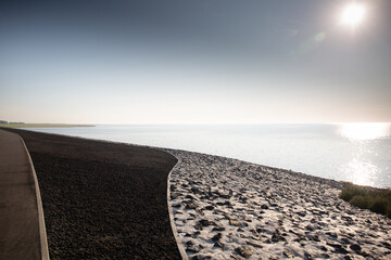 Fototapeta premium Spaziergang über einen Steindeich an der Nordseeküste