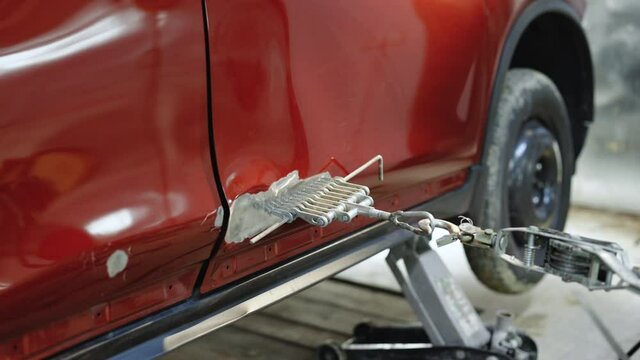 Car repair after the accident. Body work restoration of paintwork. Car repair shop, pulling out dents . Professional body repair. Auto body repair series Mechanic repair car body