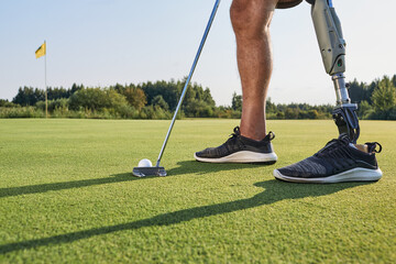 Golf for people with disabilities and with leg amputation. Man with a artificial leg playing golf...