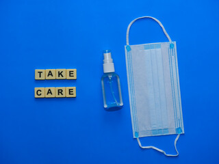 Top view of facemask, spray hand sanitizer and square alphabets 