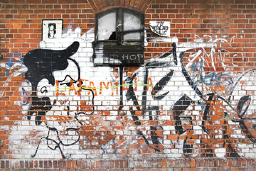 Znak "tu można palić" na ceglanej ścianie starego dworca z graffiti 