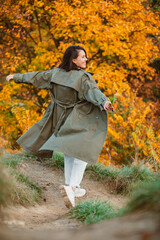 smiling woman in front of golden autumn leaves