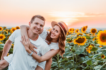 cute couple at sunflowers field on sunset