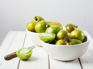 Green zebra tomatoes in a bowl. © Nataliia Sirobaba