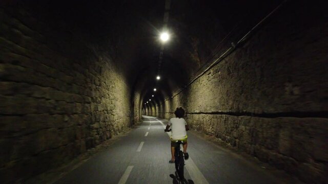 Italy, Spezia, Liguria - The new pedestrian walk , cycle path ( bicycle lane ) that connects Framura, Bonassola and Levanto passing through the ancient train tunnels - 7 years old child go bike
