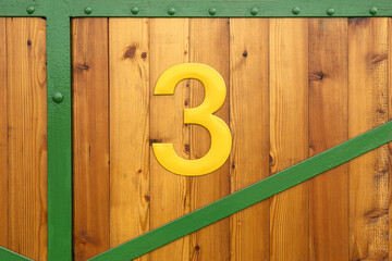 Yellow Sign Number three on wood background , indication and information.