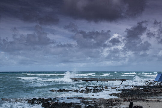 Waves from tropical storm Ida as it blows through the Cayman Islands pummel the dock in West Bay