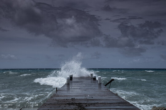 Waves from tropical storm Ida as it blows through the Cayman Islands pummel the dock in West Bay